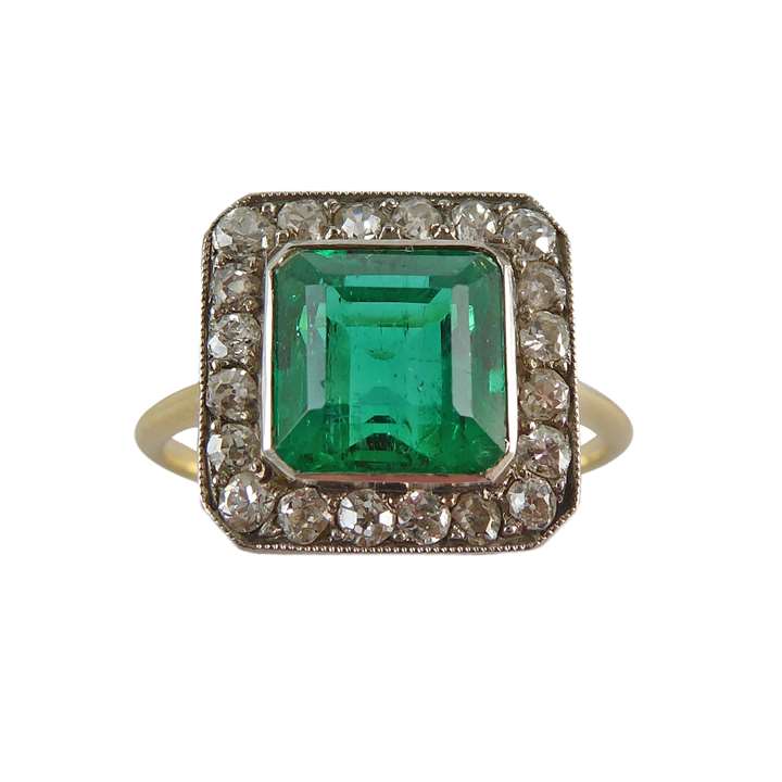 Early 20th century single stone emerald and diamond cluster ring, English c,1905, the Colombian square step-cut emerald of approximately 1.50ct,
